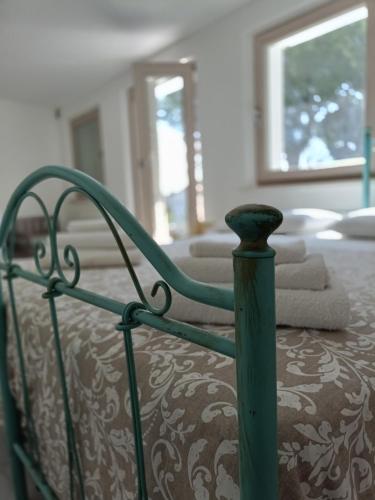 a bed with a green frame with towels on it at b&b RetrO'Conero in Castelfidardo
