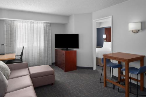 a hotel room with a couch and a tv and a table at Residence Inn by Marriott San Diego Downtown in San Diego