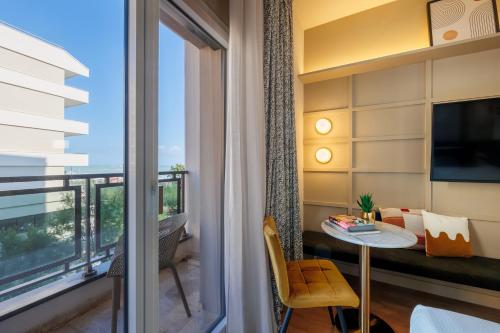 a room with a balcony with a table and a window at Charlie in Pesaro in Pesaro