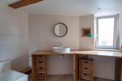 een badkamer met een wastafel en een spiegel bij Le Molsheim - Grand appartement proche Musée dArt Moderne in Straatsburg