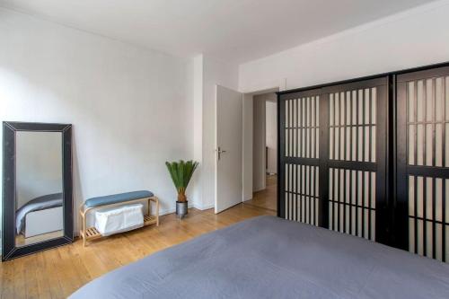une chambre avec un grand lit et un miroir dans l'établissement L'Escapade Urbaine - Exceptionnel Charmant 3 pièces proche Cathédrale, à Strasbourg
