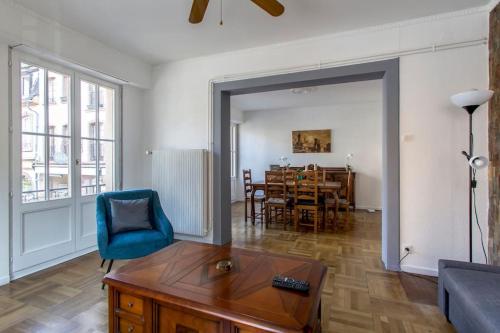 un salon avec une chaise bleue et une table dans l'établissement L'Escapade Urbaine - Exceptionnel Charmant 3 pièces proche Cathédrale, à Strasbourg