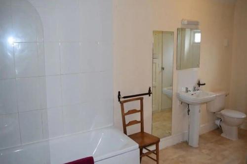 a bathroom with a tub and a sink and a toilet at The Cranley Hotel in Cranleigh