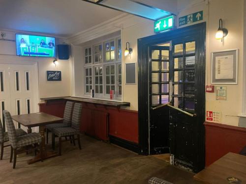 um bar com mesa e cadeiras num restaurante em The Cranley Hotel em Cranleigh