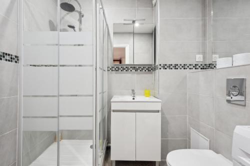 une salle de bain blanche avec un lavabo et des toilettes dans l'établissement Budget appart avec parking au centre-ville, à Charleville-Mézières