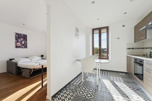 une cuisine et un salon avec une table et un canapé dans l'établissement Budget appart avec parking au centre-ville, à Charleville-Mézières