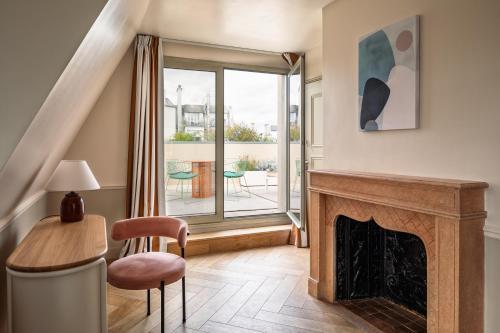 a living room with a fireplace and a table and chairs at Royal Garden Champs-Élysées in Paris