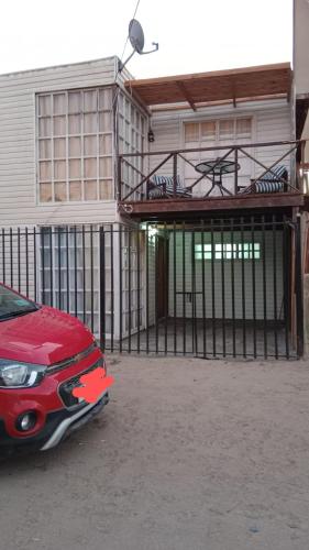 a red car parked in front of a house at Cabaña playa in Coquimbo