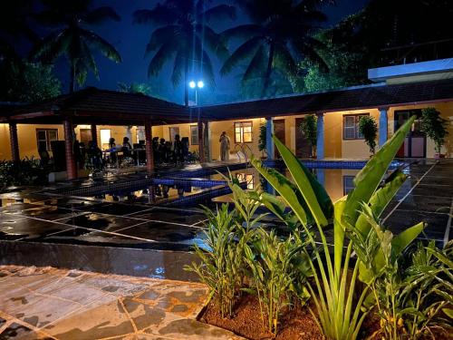 a resort with a swimming pool at night at Ooru homestay in Udupi