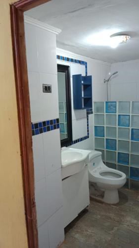 a white bathroom with a toilet and a sink at Cabaña playa in Coquimbo