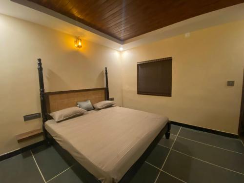 a bedroom with a bed with a flat screen tv at Ooru homestay in Udupi