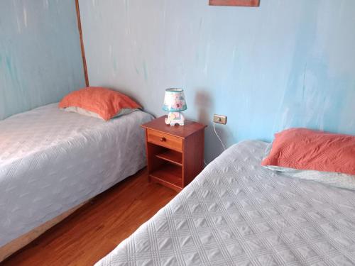a bedroom with two beds and a lamp on a night stand at Cabaña playa in Coquimbo