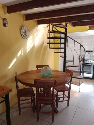 a dining room table with chairs and a clock on the wall at Cabaña playa in Coquimbo