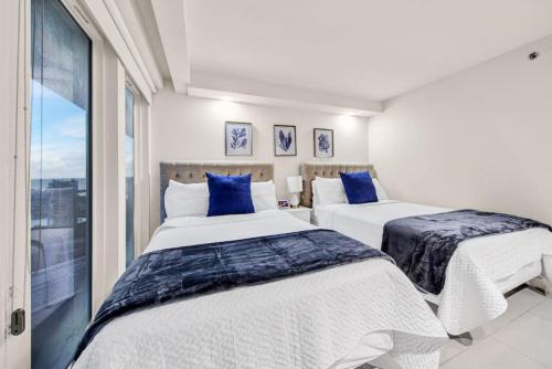 deux lits dans une chambre avec une fenêtre dans l'établissement Jackpot Beachfront Condo With Amazing Sunset Views, à South Padre Island