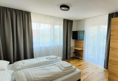 a hotel room with two beds and a window at Mountains & Lakes - Chaletdorf in Villach