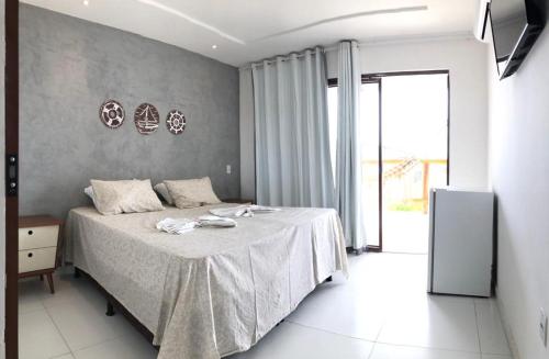 ein Schlafzimmer mit einem Bett mit einer grauen Wand in der Unterkunft Pousada farol in Areia Branca
