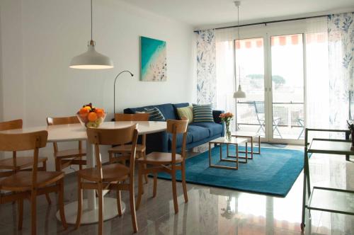 un salon avec une table et un canapé bleu dans l'établissement Résidence MANDARINIERS Cannes, à Cannes