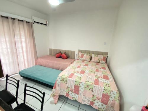a bedroom with a bed and chairs in it at Apto Santos Gonzaga 50mtrs Praia in Santos