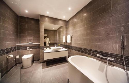 a bathroom with a tub and a toilet and a sink at Crowne Plaza Leeds by IHG in Leeds