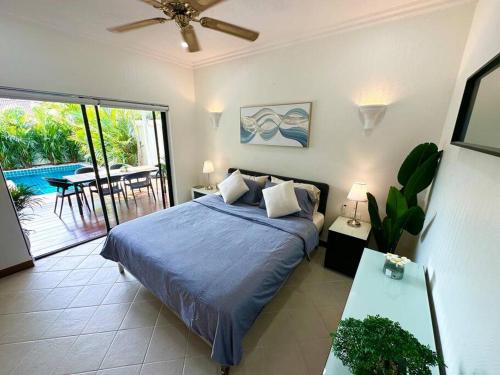 1 Schlafzimmer mit einem Bett und einem Balkon mit einem Tisch in der Unterkunft View Talay Villas - Luxury 1BR pool villa nr beach - 171 in Jomtien Beach