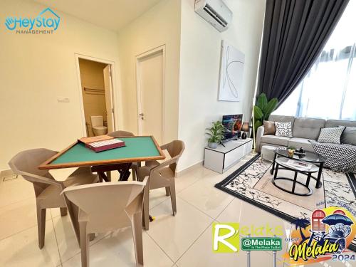 a living room with a table and chairs at The Apple Residence By Heystay Management in Melaka