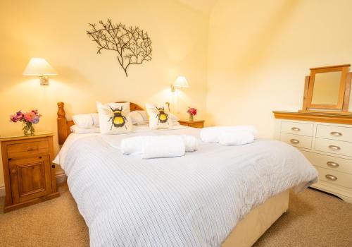 a bedroom with a large bed with white sheets at Sychpant Barn in Velindre