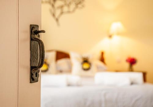 a doorhandle to a bedroom with a bed in the background at Sychpant Barn in Velindre