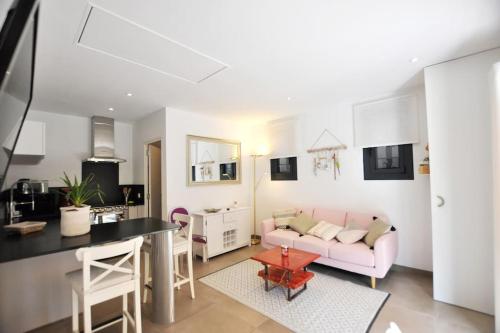 une cuisine et un salon avec un canapé rose dans l'établissement Evasion en milieu forestier, à Argelès-sur-Mer