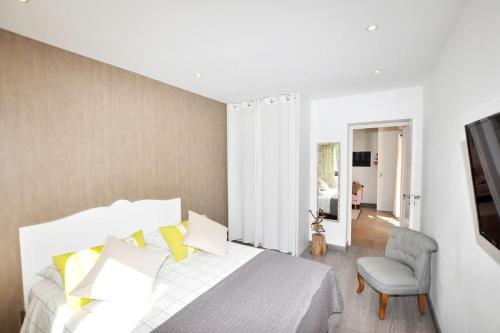 une chambre avec un grand lit et une chaise dans l'établissement Evasion en milieu forestier, à Argelès-sur-Mer