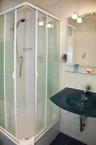 a bathroom with a glass shower and a sink at Hotel bei Liebe's in Erlenbach am Main