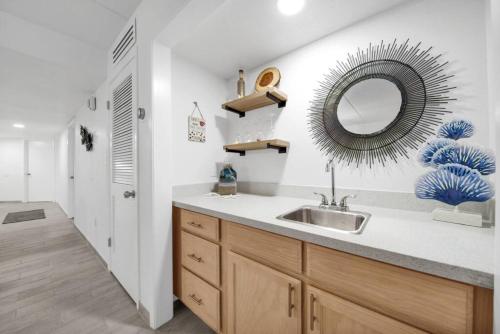 Un baño con un lavabo y un espejo en la pared. en Amazing 6th floor beachfront condo wonderful views, en South Padre Island