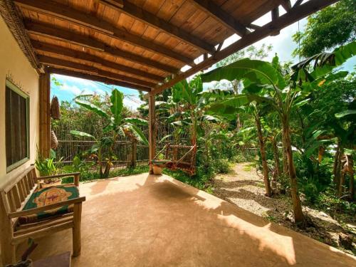 a covered patio with a bench and some trees at Mawingu lodge in Kizimkazi