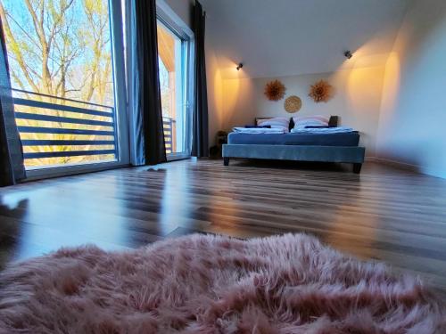 a bedroom with a bed and a rug on the floor at Dom nad jeziorem WIDOKówka in Żywiec