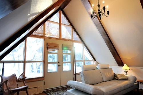 a living room with a couch and some windows at Appartement Jacques Cartier in Saguenay