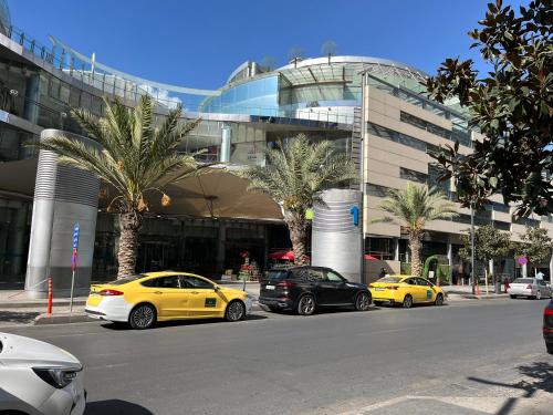 tres autos estacionados en un estacionamiento frente a un edificio en DAMAC Luxury new 1 bedroom apartment, en Amán