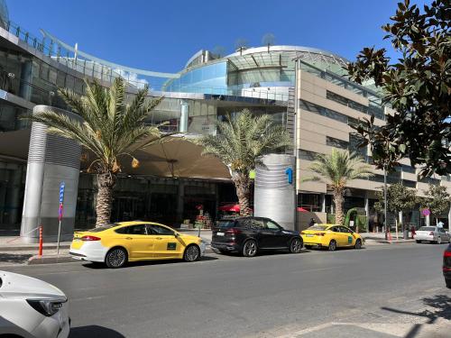 three cars parked in a parking lot in front of a building at DAMAC Luxury new 1 bedroom apartment in Amman