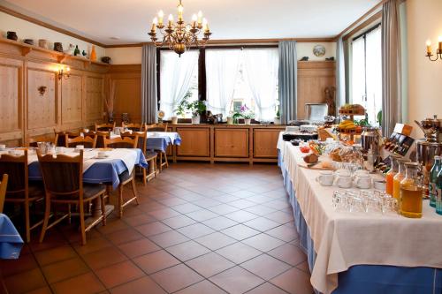 un restaurant avec deux tables à nappes blanches dans l'établissement Hotel bei Liebe's, à Erlenbach am Main