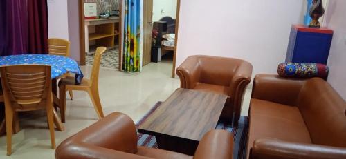 a living room with a table and chairs at Sanjana Holiday Apartment in Varanasi