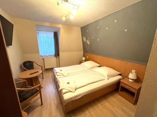 Dormitorio pequeño con cama y mesa en Hotel Alte Apotheke en Bad Dürrenberg