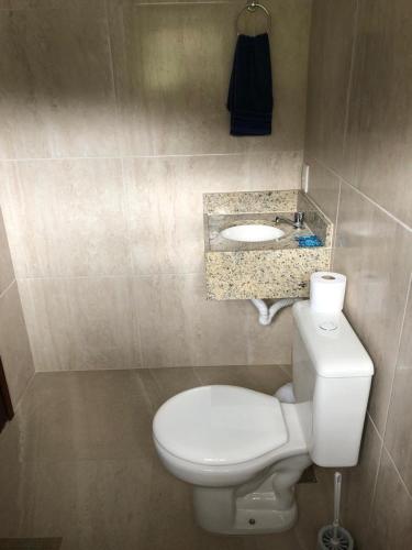a bathroom with a white toilet and a sink at Recanto dos Pássaros em Petrópolis in Petrópolis