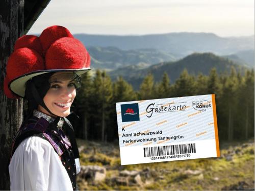 Una donna con un cappello e un cartello di Ferienwohnung Schwarzwald-Alpenblick a Lenzkirch