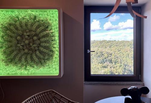 a window with a green decoration on the wall at SopraBosco Calcata Art & Design Apartment in Calcata