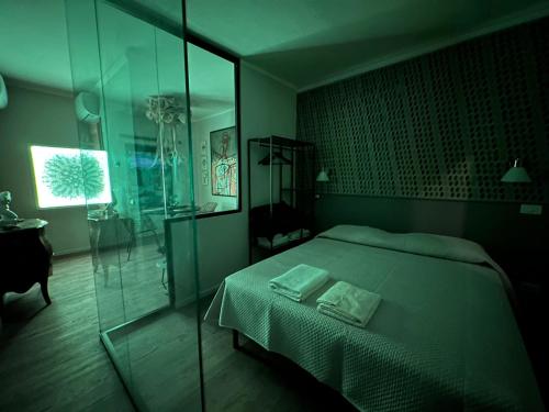 1 dormitorio con 1 cama y pared de cristal en SopraBosco Calcata Art & Design Apartment en Calcata