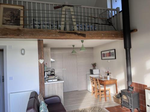 a living room and kitchen with a loft at Poachers Hut 1-Bed Cottage Sleeps 2 Pet Friendly in Shorwell