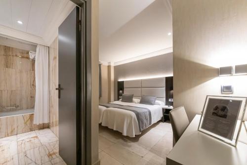 a hotel room with a bed and a bathroom at Habitus Hotel Europa in Pamplona