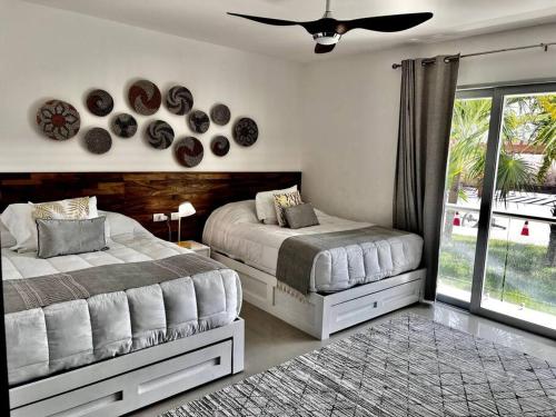 a bedroom with two beds and a window at MAREAZUL Beachfront Apartment 2BR Private Pool Casa Áncora in Playa del Carmen