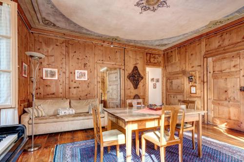 a dining room with a table and chairs and a couch at Casa Pool tra St Moritz e il lago di Como in Castasegna