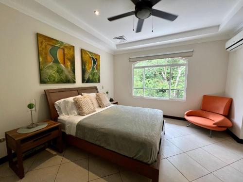a bedroom with a bed and a window and a chair at Spacious Penthouse with pool & Jungle Views in La Mona