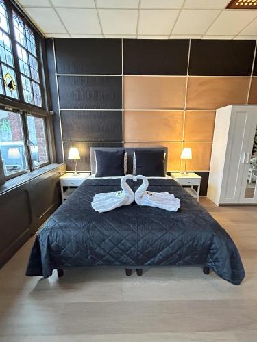 a bedroom with a large bed with two towels on it at Cozy independent Studio S2, City Centre Dordrecht in Dordrecht