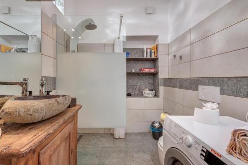 een badkamer met een wastafel en een wasmachine bij In val Bregaglia mille possibilità di benessere in Castasegna